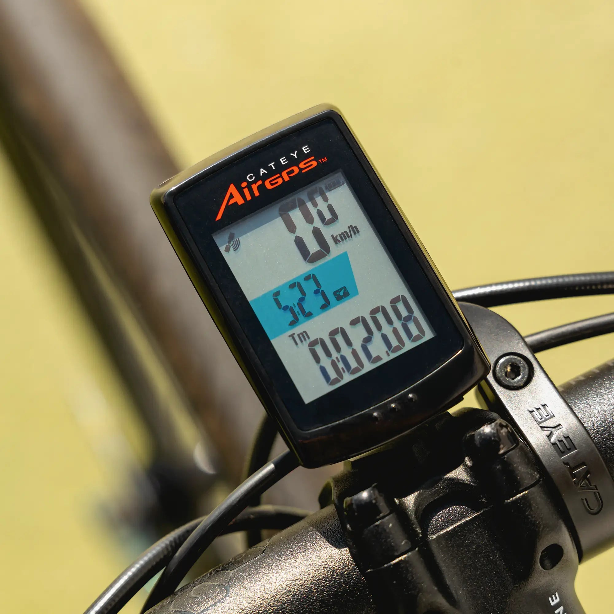 A close-up of the CATEYE AirGPS bike computer on handlebars, showing speed, distance, time, and more on its screen with reliable GPS accuracy and compatibility with the CATEYE Cycling app.