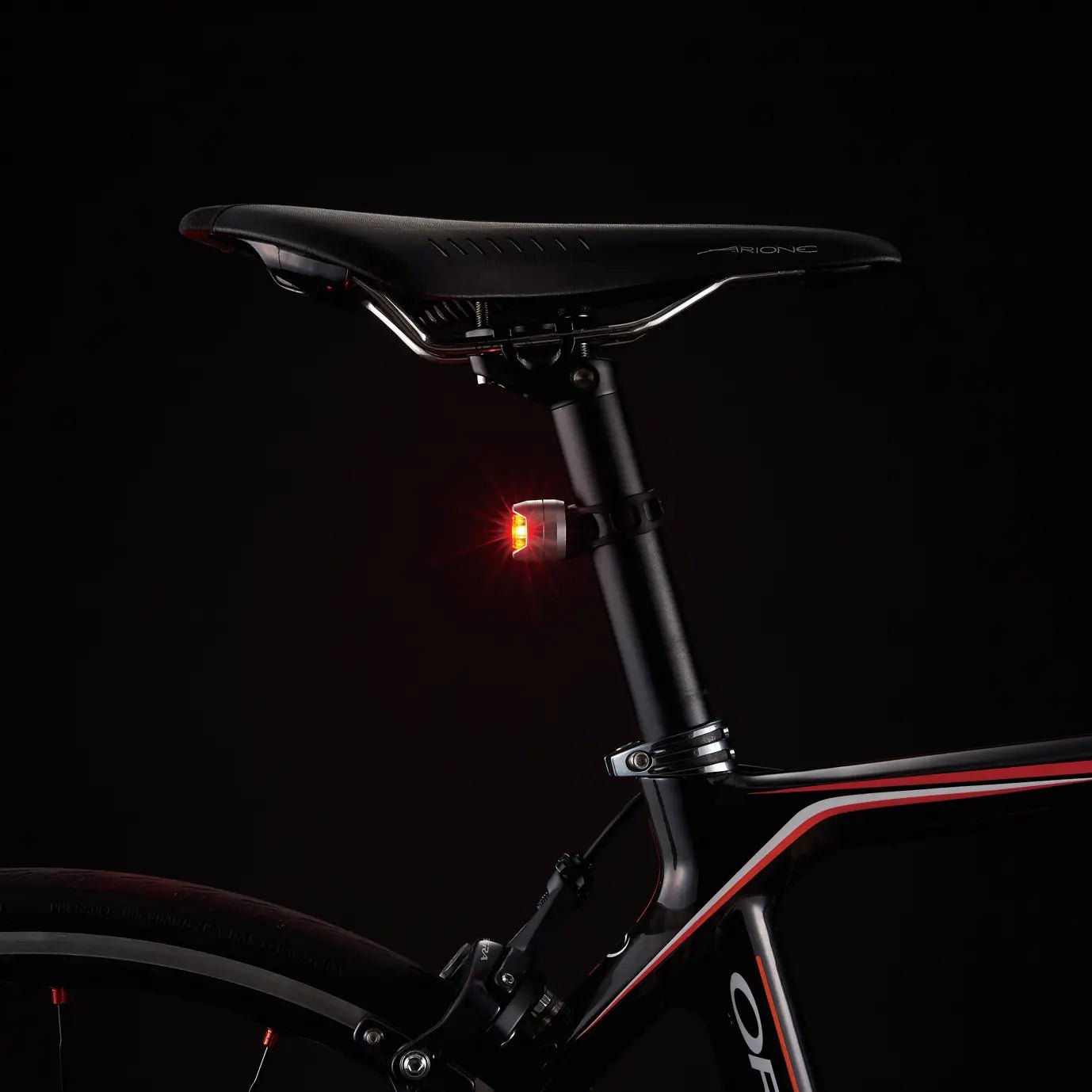 A close-up of a CATEYE ORB bicycle seat rear safety light with multiple lighting modes, attached to the seat post against a dark background.