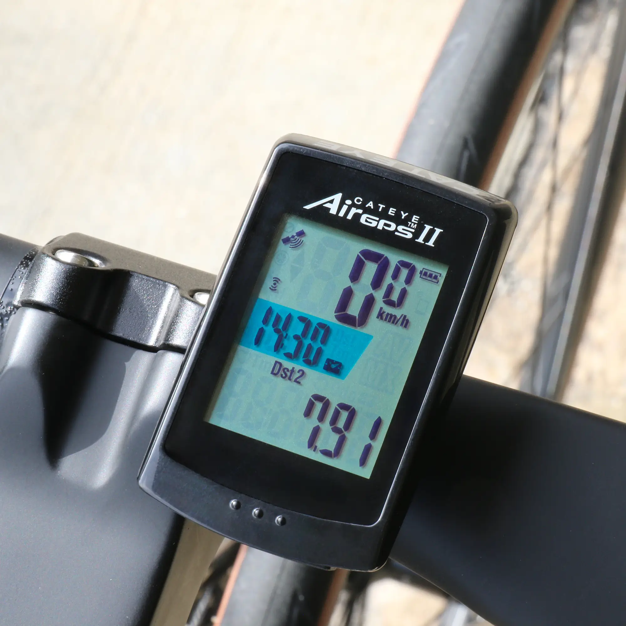 A close-up of the CATEYE AirGPS II bike computer on a handlebar shows 0.0 km/h speed, 14.30 km distance, and a trip value of 7.91, highlighting the device’s GPS accuracy for reliable cycling tracking.